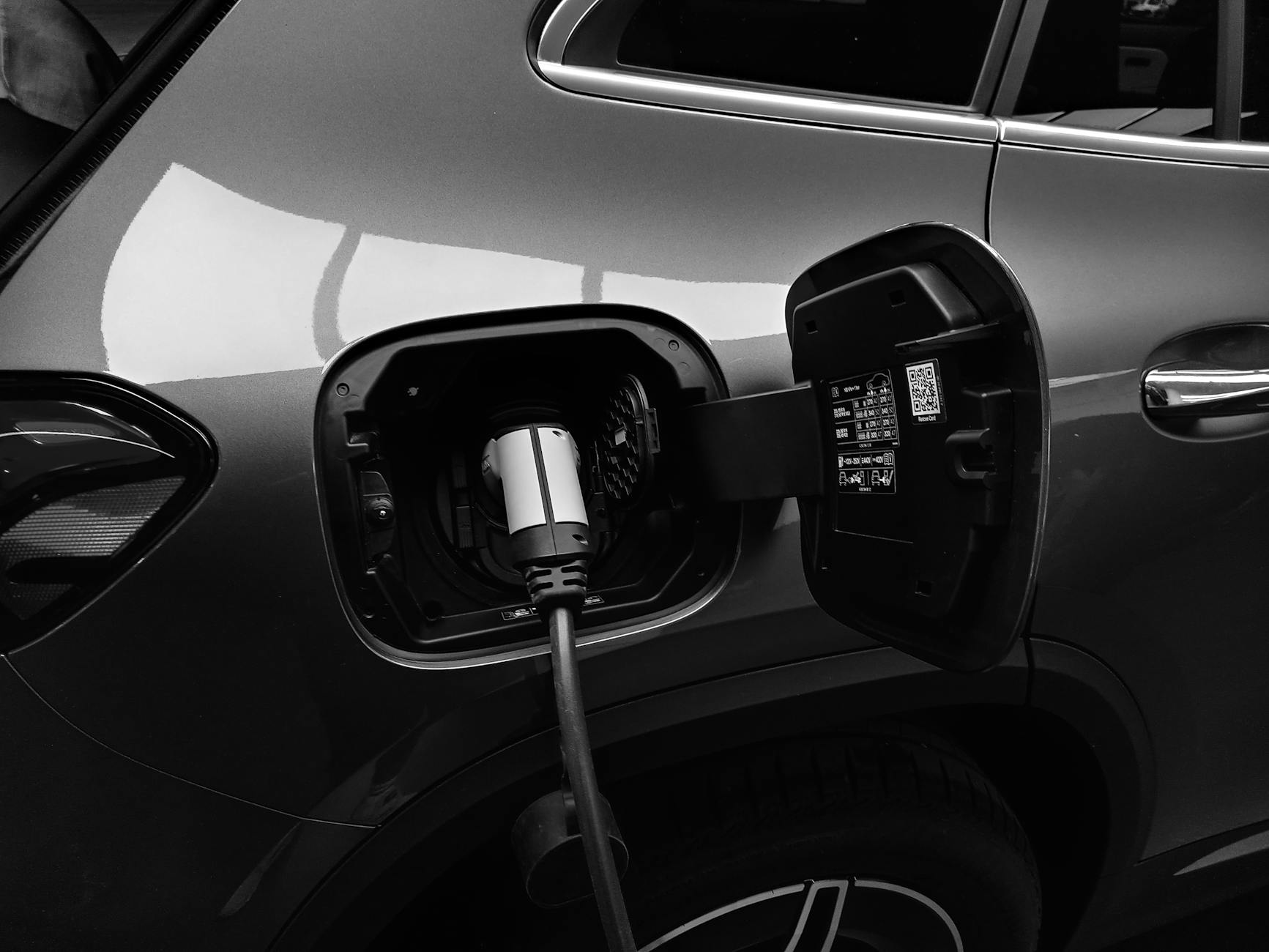 monochrome photo of hybrid car charging